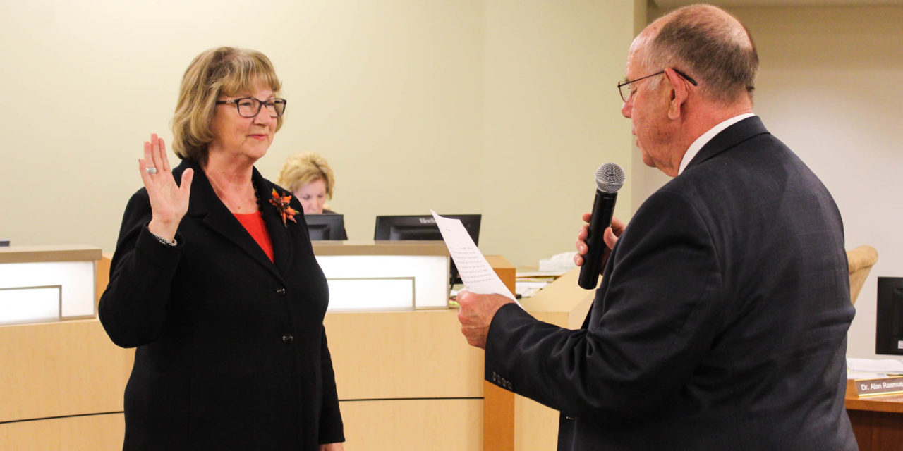 Two Board members take a familiar oath