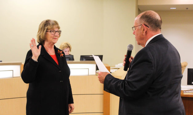 Two Board members take a familiar oath